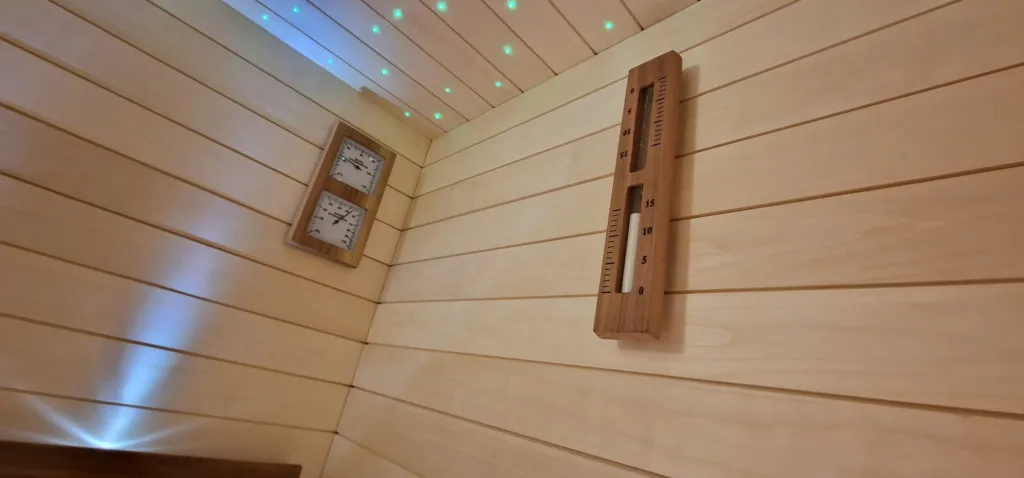Szauna hőmérő, páratartalom-mérő és homokóra a fal lambérián